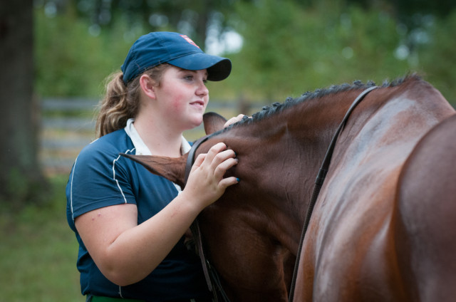 Groom Rachael Tuscher gives her charge, Carolina Fairfax, some well deserved snuggles after dressage on Saturday. Photo by Leslie Threlkeld.