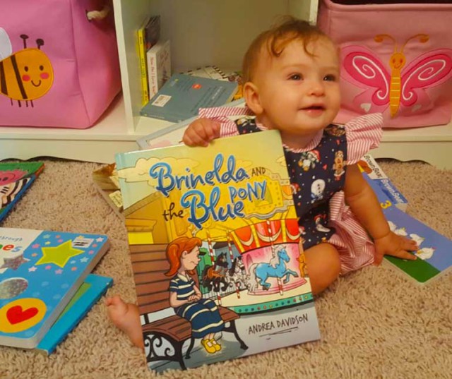 Aubrey Davidson proudly displays her mom's new book. Photo courtesy of Andrea Davidson.